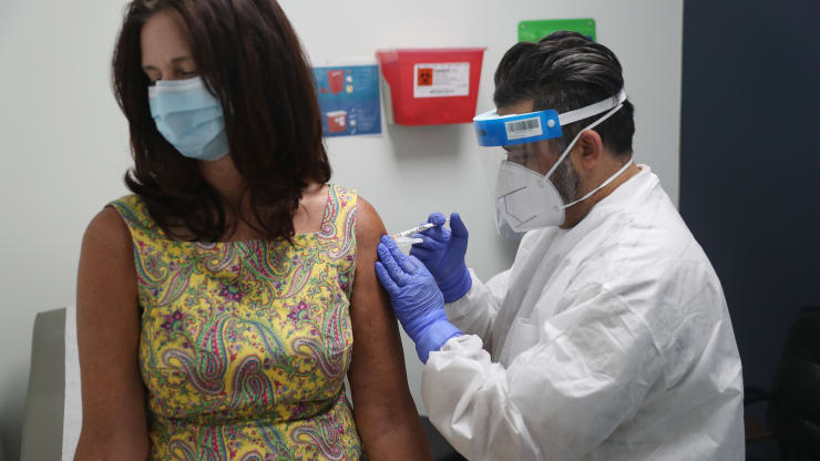 Lisa Taylor receives a COVID-19 vaccination from RN Jose Muniz as she takes part in a vaccine study at Research Centers of America on August 07, 2020 in Hollywood, Florida.